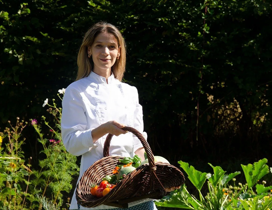 Lali Wanderley, panier de légumes à la main, dans le bocage