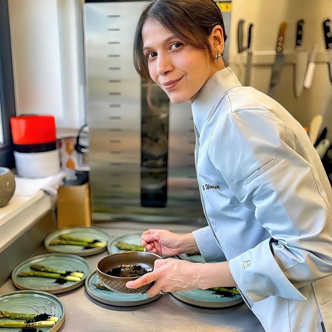 Lali Wanderley en cuisine, souriante, dressant des asperges vertes