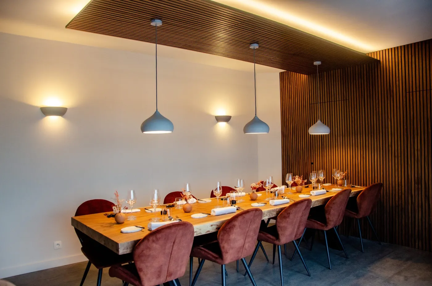 La salle de Mysa : table conviviale, fauteuils terracotta et bois clair
